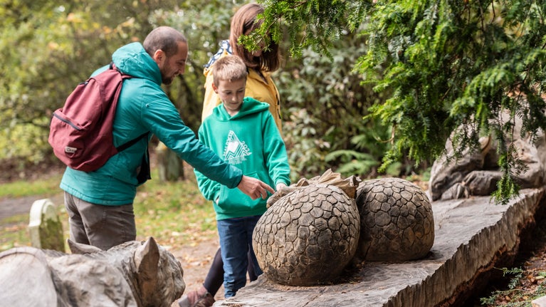 Visitors with the Wyvern sculpture by Simon O'Rourke at Powis Castle, Powys, Wales